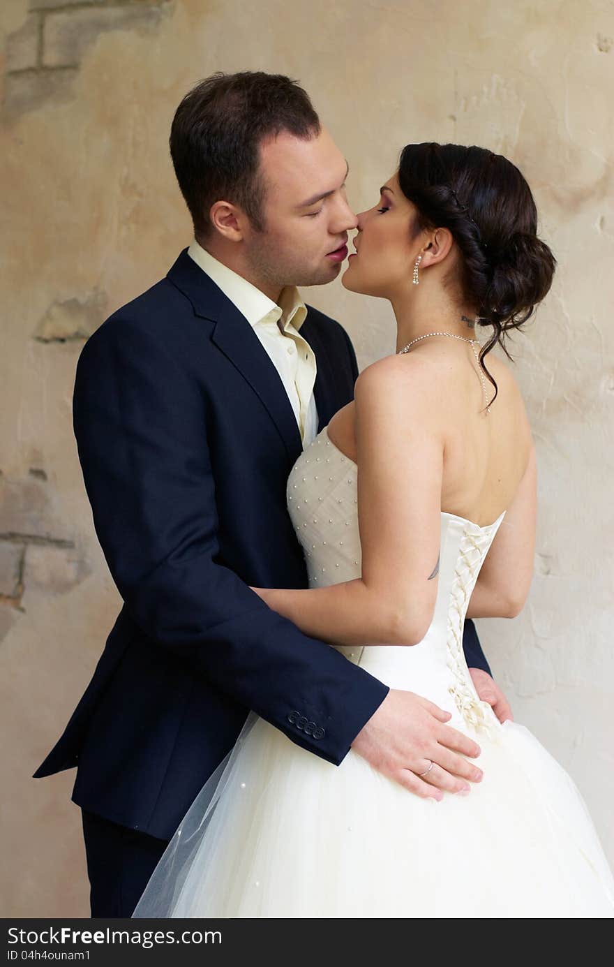 Groom kisses bride in empty room