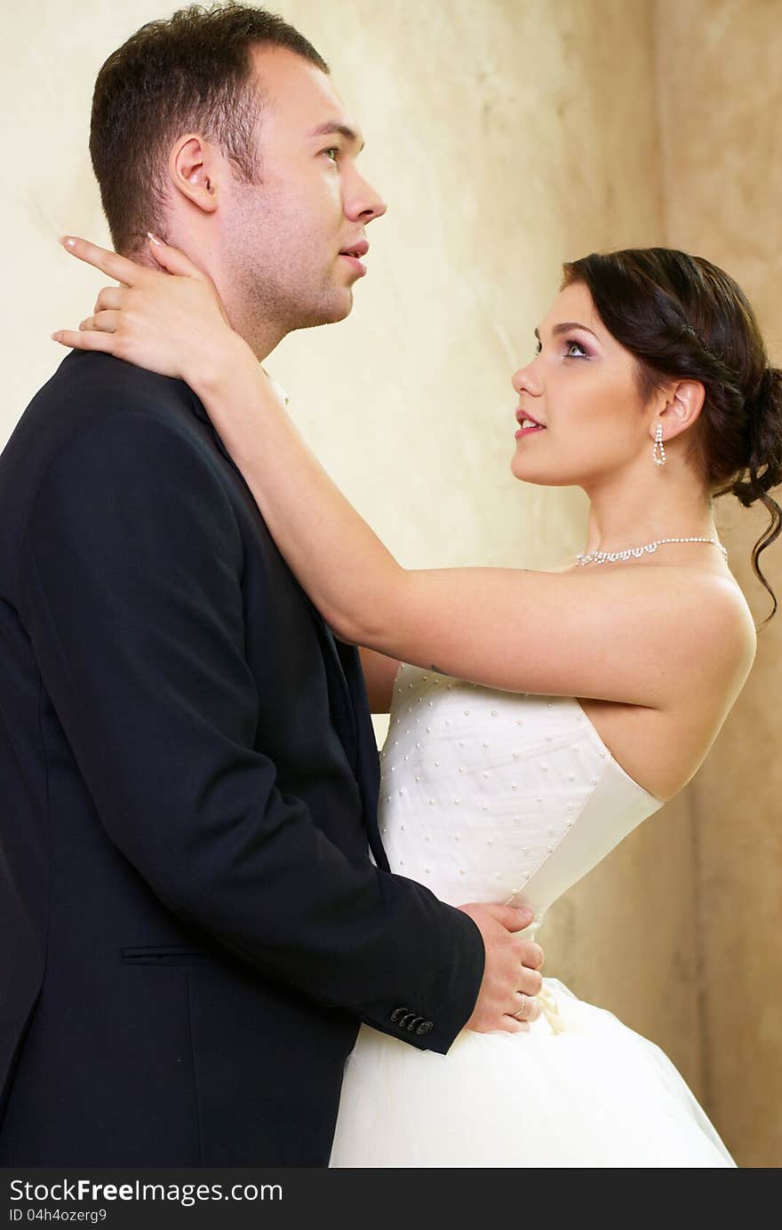 Bride and groom hugging in stylish empty room. Bride and groom hugging in stylish empty room