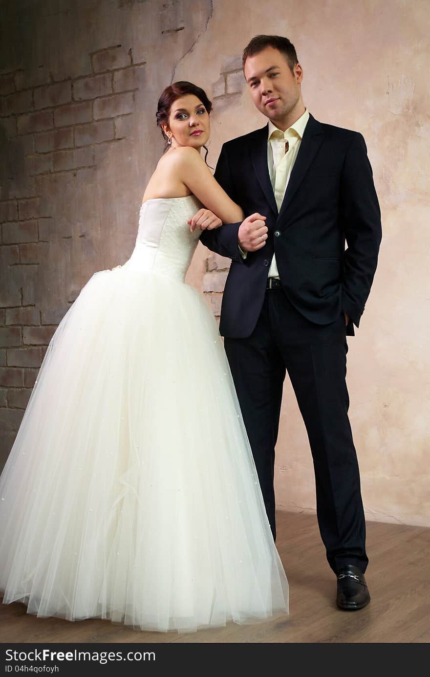 Bride and groom standing in stylish empty room. Bride and groom standing in stylish empty room