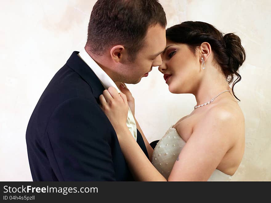 Groom kisses bride in stylish empty room. Groom kisses bride in stylish empty room