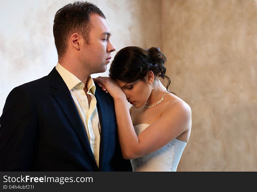 Bride and groom standing in empty room