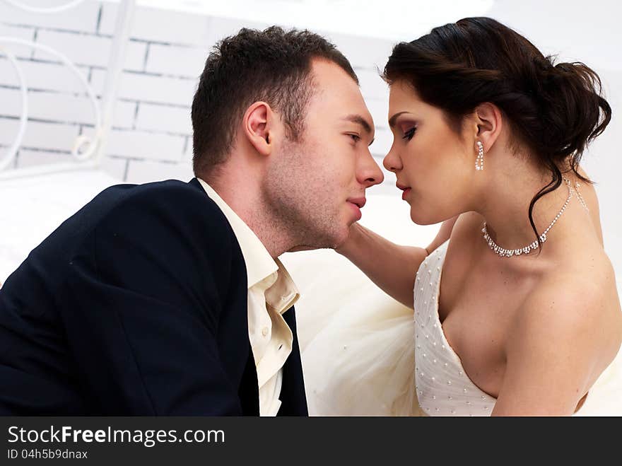 Bride and groom lying in bedroom with orchids