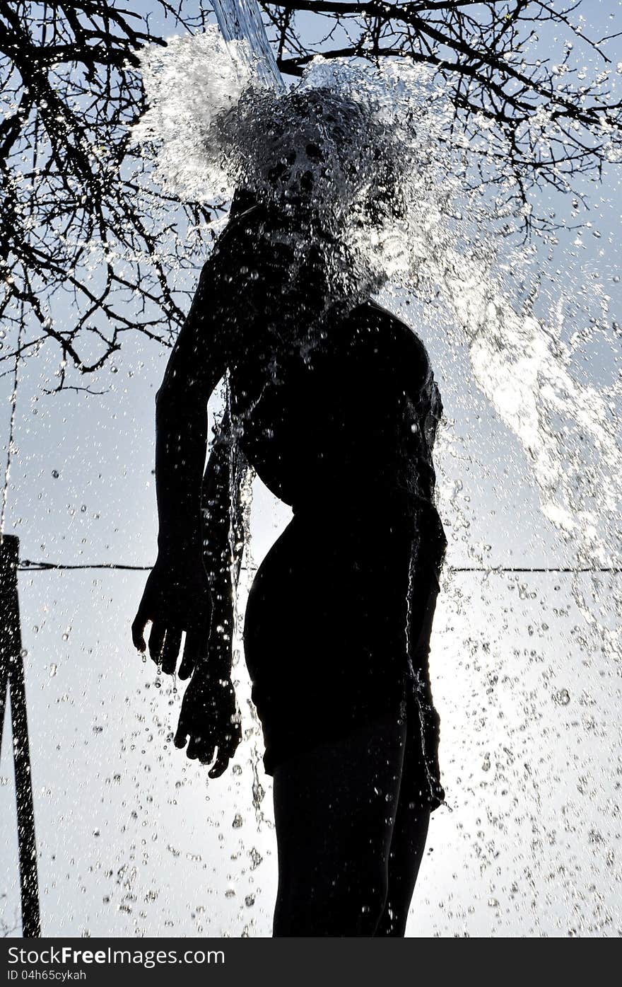 Sexy woman enjoys the water splash in the outdoors