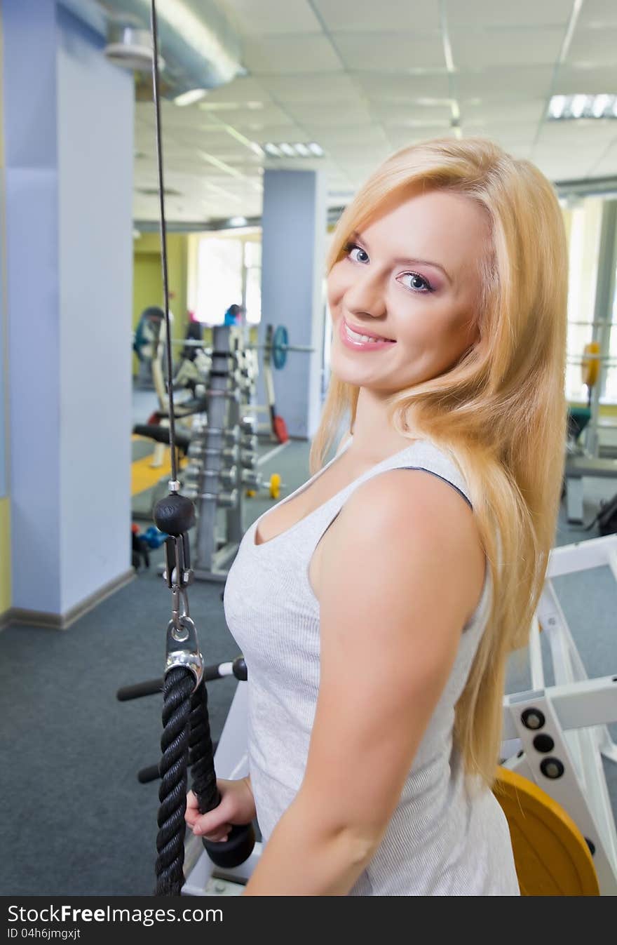 Woman at the gym exercising on a machine. Woman at the gym exercising on a machine