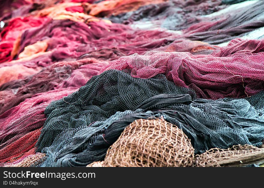 Red fishing nets drying on the port