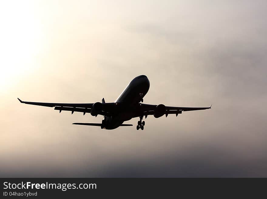 Silhouette of jet aircraft against a cloudy sky