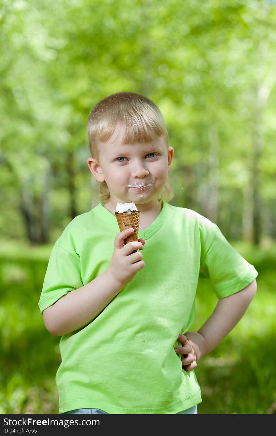 Happy kid eating a tasty ice cream outdoors