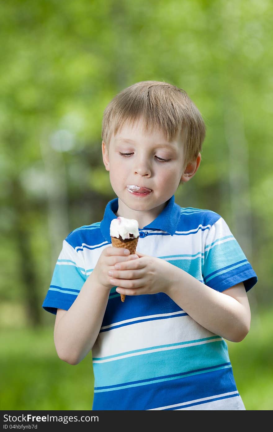 Happy kid eating a tasty ice cream outdoor