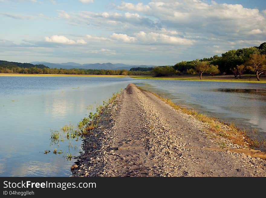 Gravel road ending into the lake.