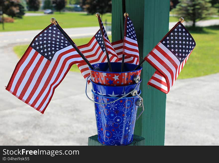 Pretty little patriotic buckets with American flags displayed to celebrate the 4th of July. Pretty little patriotic buckets with American flags displayed to celebrate the 4th of July.