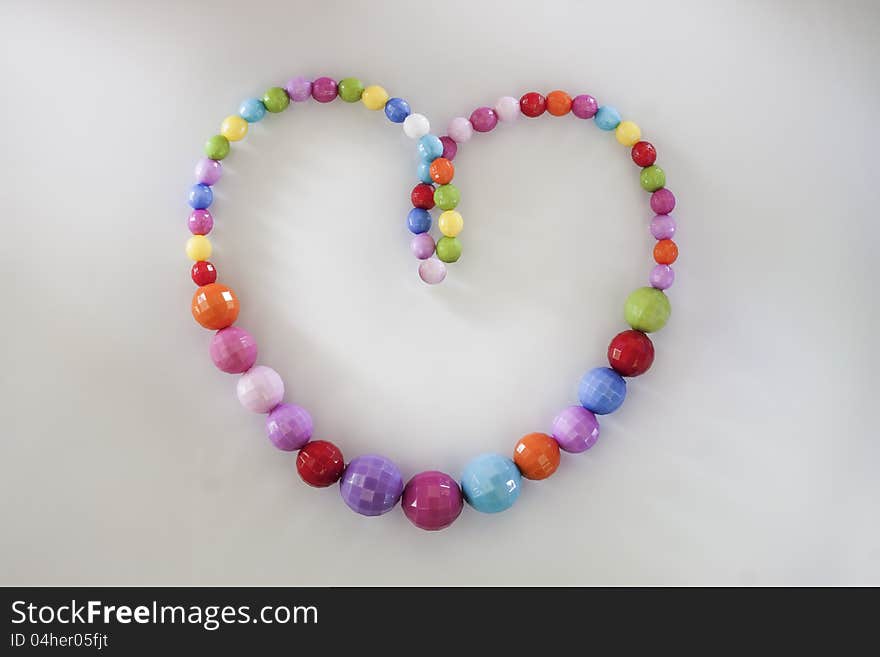 A colorful heart necklace on white background