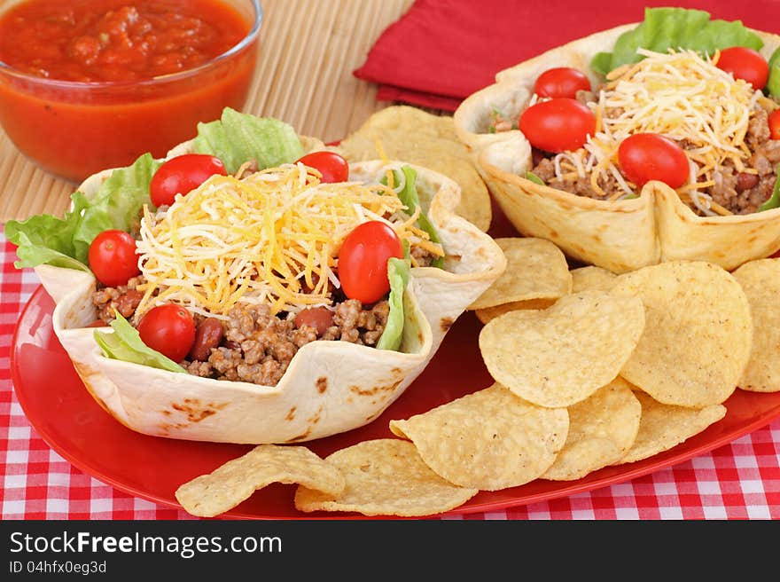 Taco salads in tortilla shells with chips and salsa