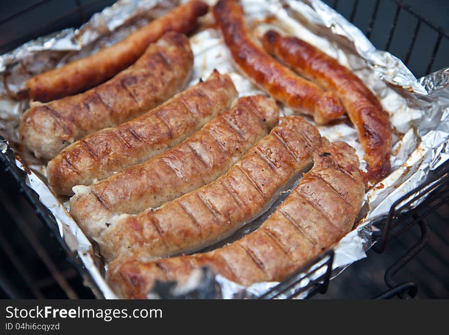 Sausages on the grill in a foil. Sausages on the grill in a foil