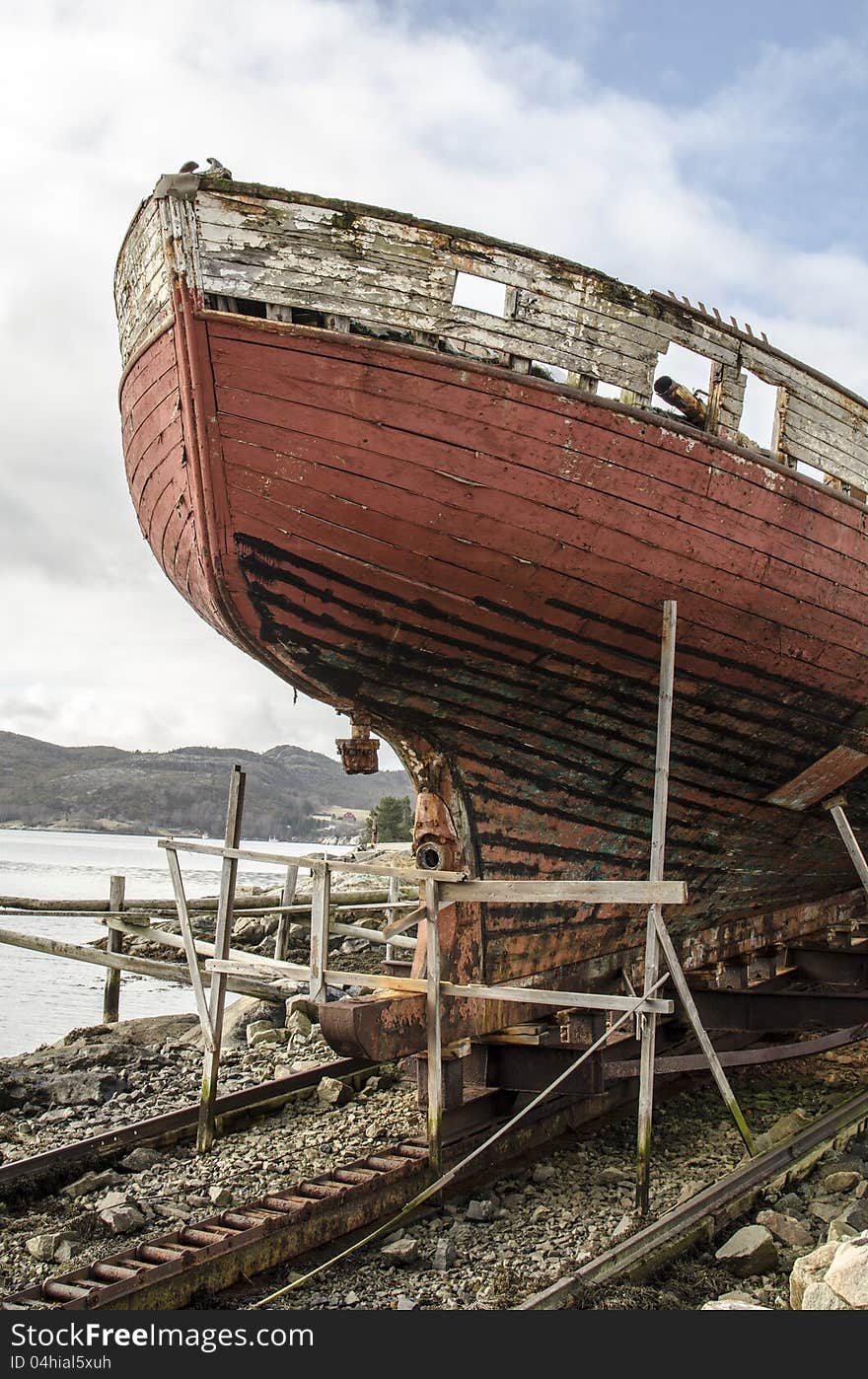 Old rusty wood ship on shore