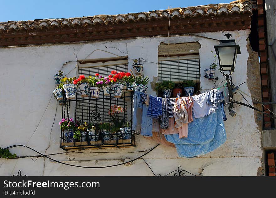 Hanging clothes and flowered balcony.