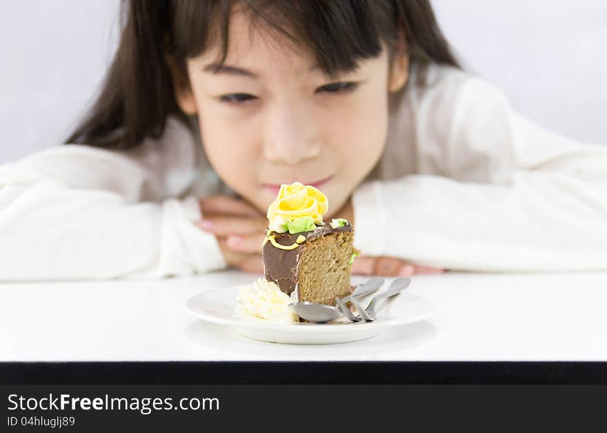 The girl stared cake for overcome by a temptation to eat a slice of a sweet cake