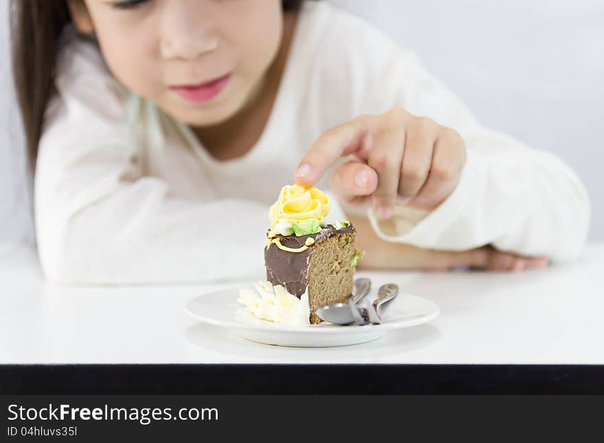 The girl stared cake for overcome by a temptation to eat a slice of a sweet cake