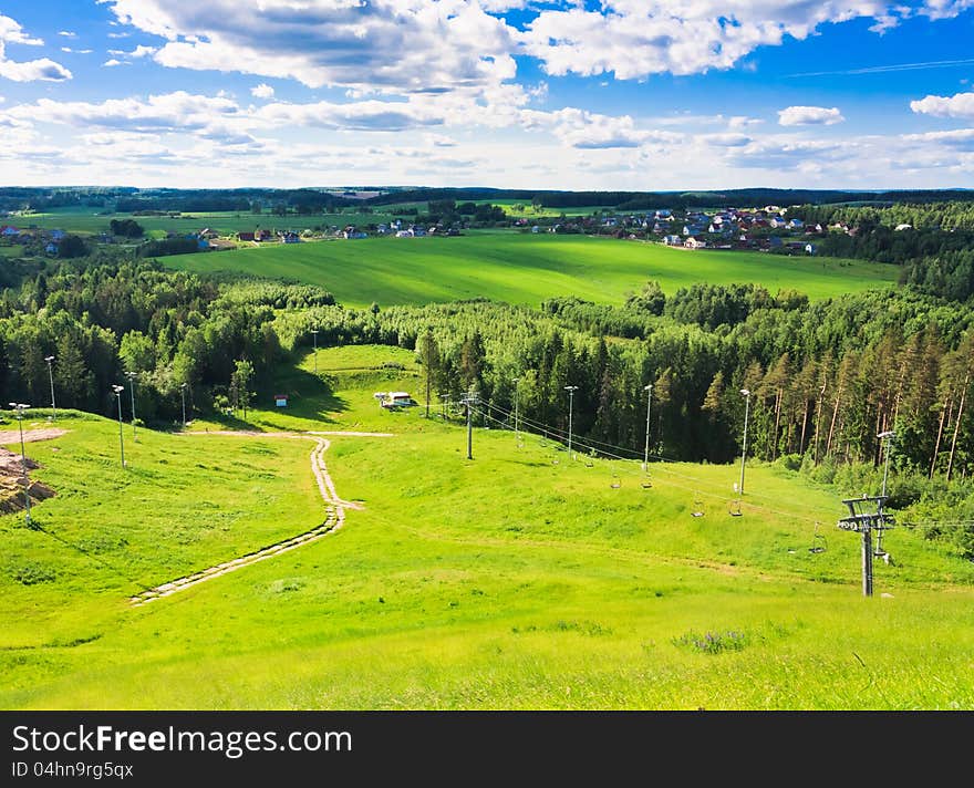 With mountains, pastures, and footpath. With mountains, pastures, and footpath