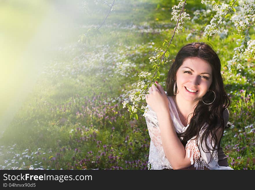 Image of a beautiful girl in the park against the backdrop of flowering trees