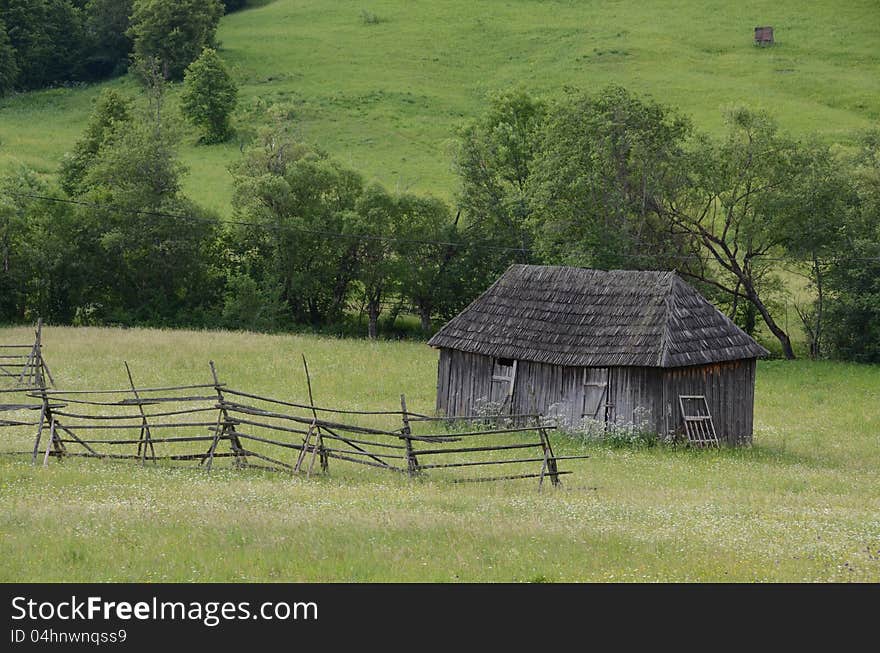 Autumnal green hill with wooden fence and cottage. Autumnal green hill with wooden fence and cottage