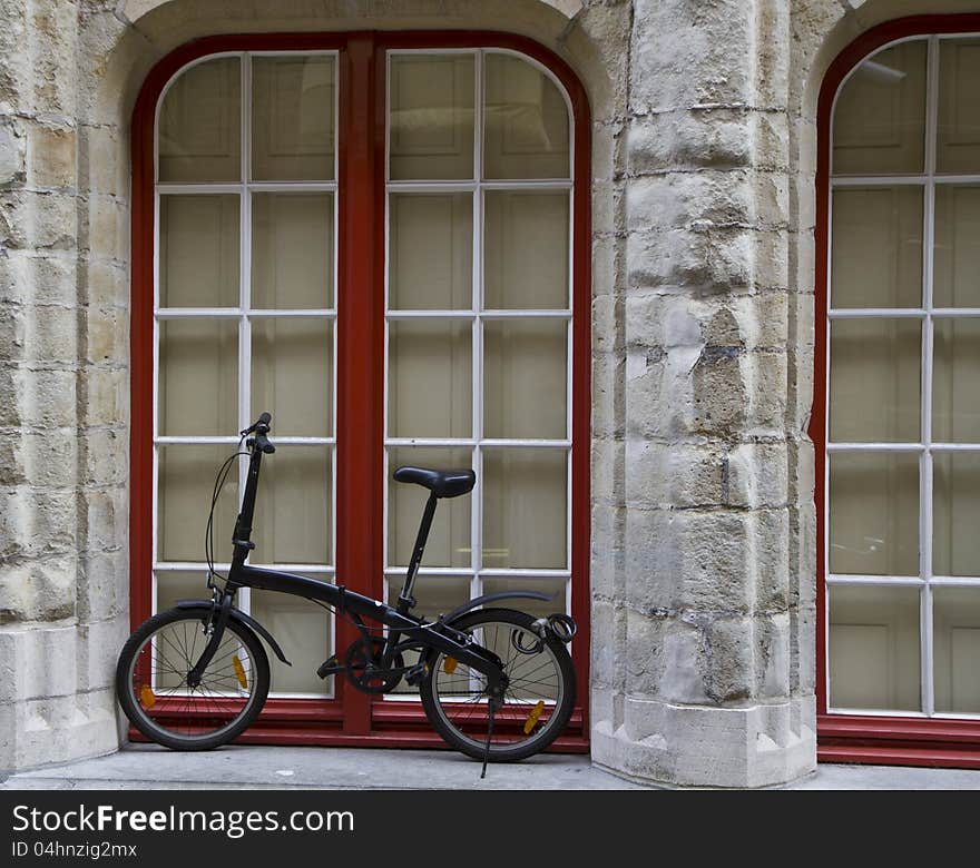 Bicycle standing against a wall under a window. Bicycle standing against a wall under a window