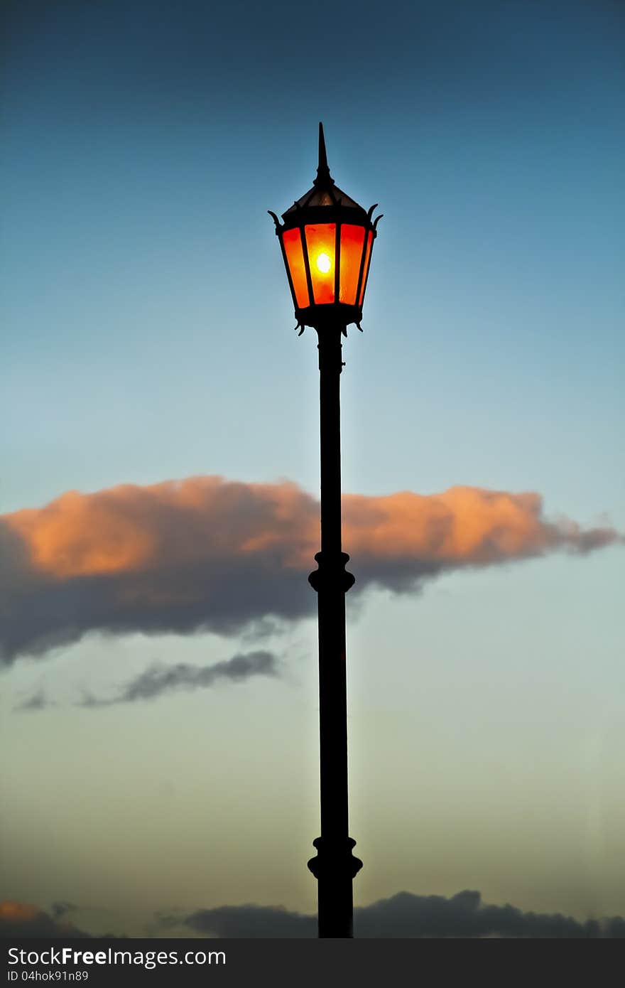 Lit old streetlamp at sunset in Argentine. Lit old streetlamp at sunset in Argentine.