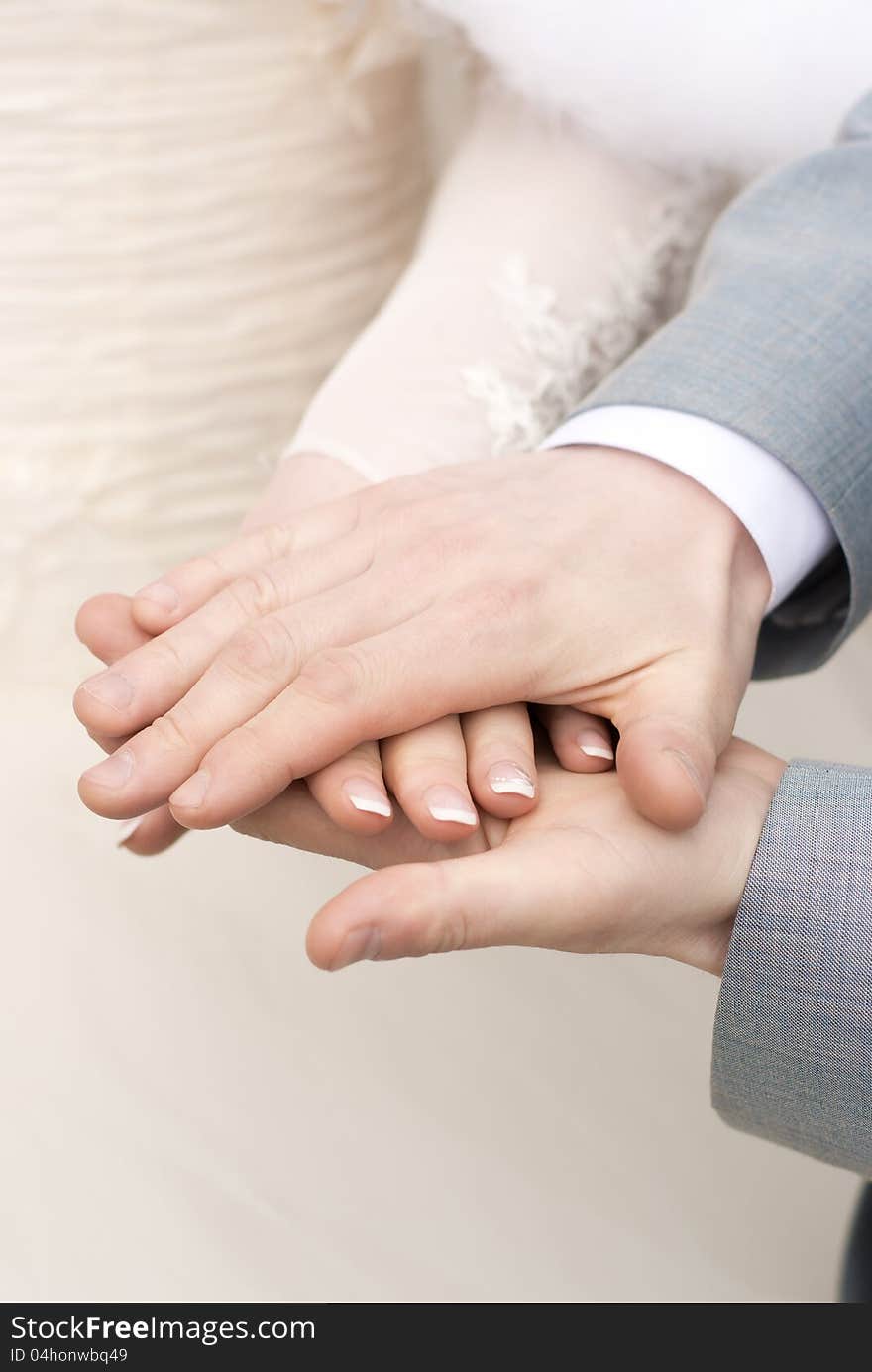 Man holding a fragile bride's hand in his strong arms. Man holding a fragile bride's hand in his strong arms