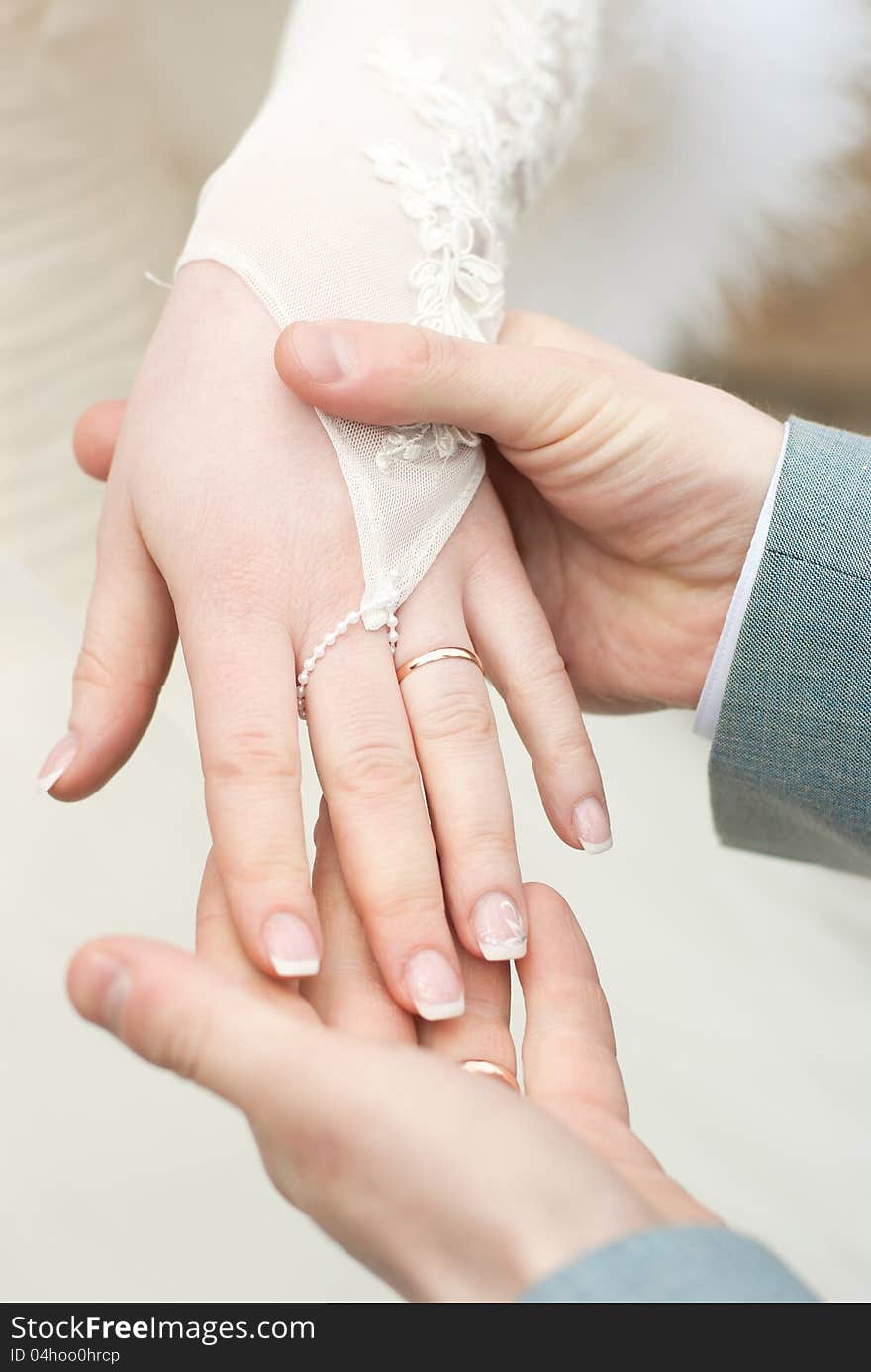 Man holding a fragile bride's hand in his strong arms, dof, close-up. Man holding a fragile bride's hand in his strong arms, dof, close-up