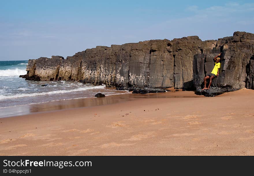 Man leaning on rocks at the seaside