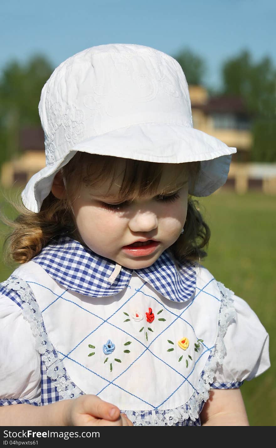 Beautiful little girl looks down outdoor