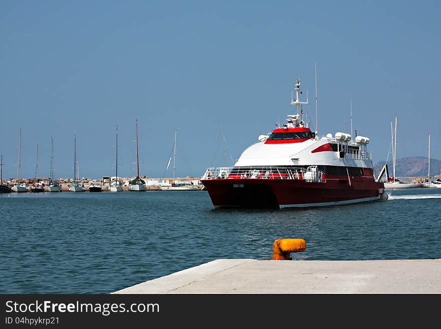 A red high speed dolphin arrive to the port of Skopelos at Greece.