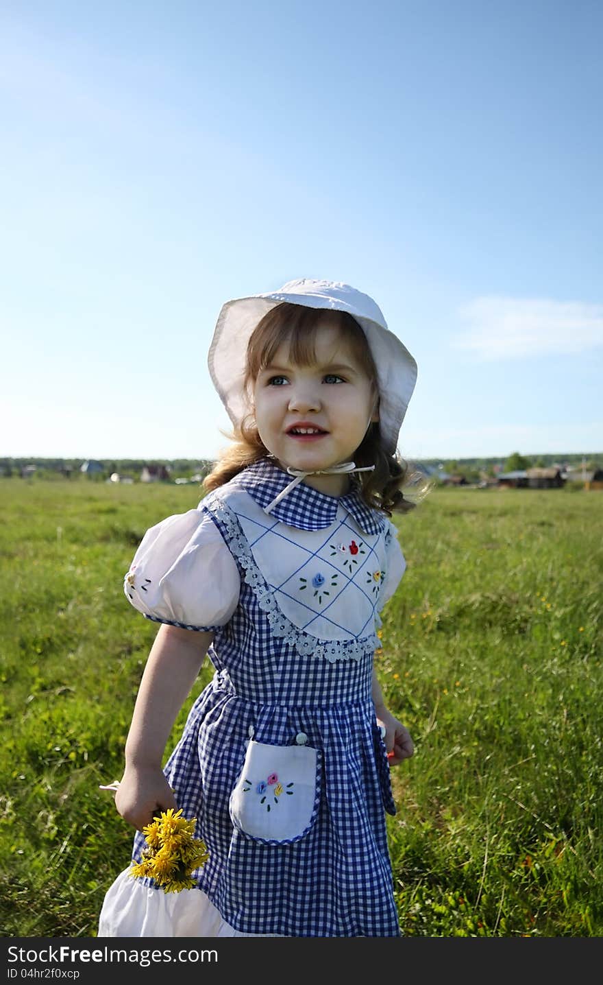 Little Girl Looks Into Distance On Green Field