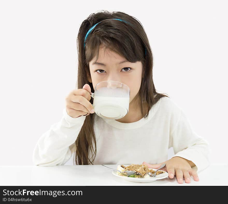 Cute girl drinking a glass of milk and eating a cake. Cute girl drinking a glass of milk and eating a cake