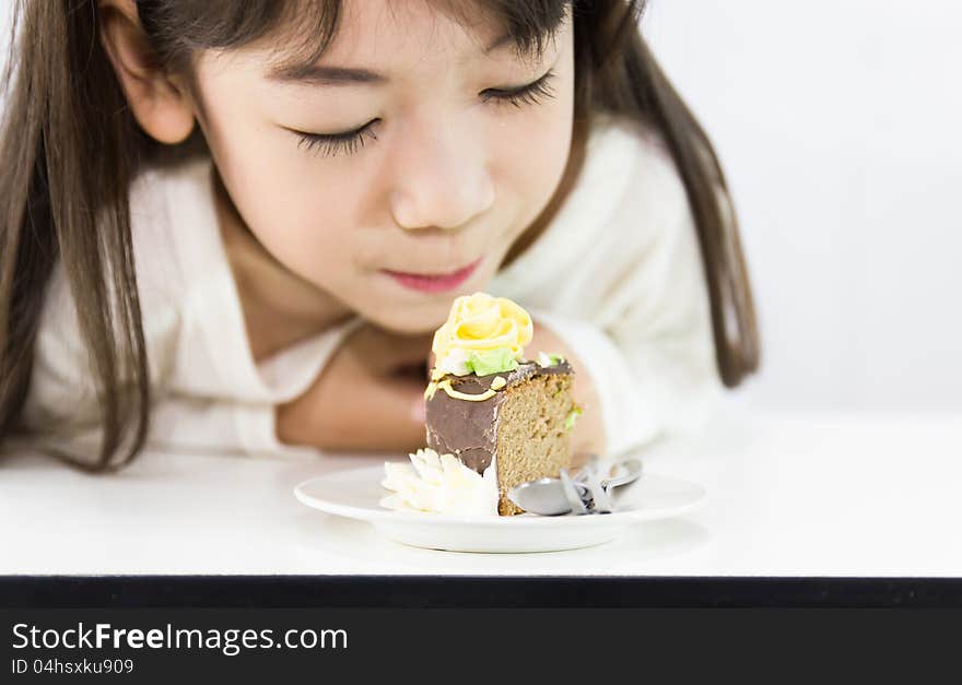 The girl stared cake for overcome by a temptation to eat a slice of a sweet cake