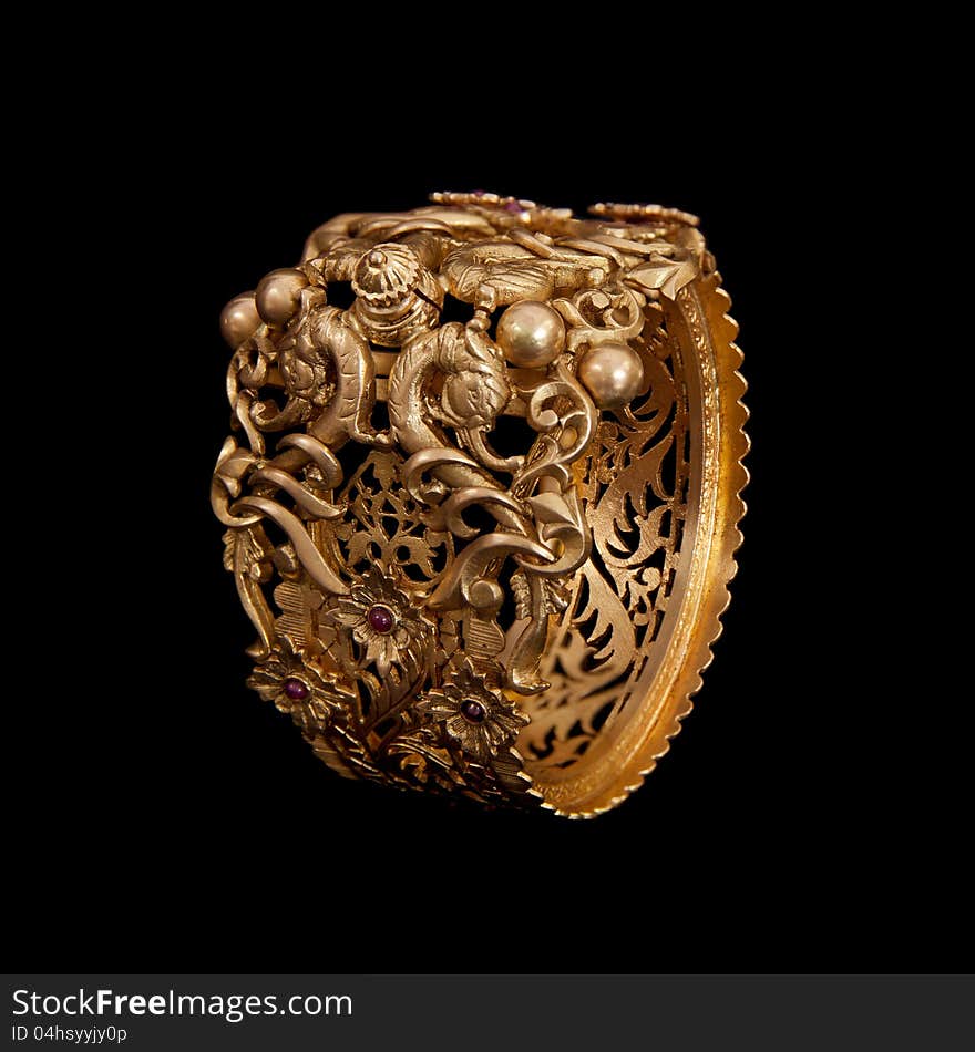 Pure Gold  bracelet  having itself craft of gold looking historic over black background