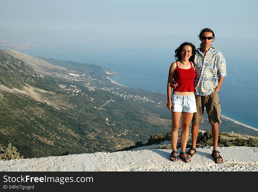 Romantic couple on a height, ocean in the background