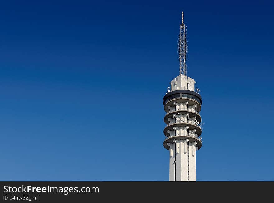 Large concrete telecommunications tower against a clear blue sky.