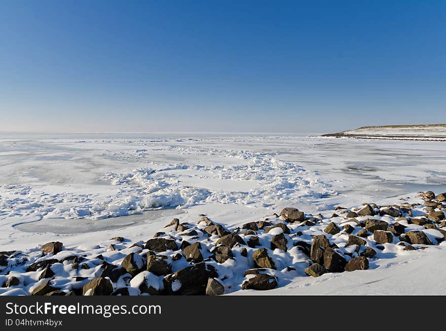 Frozen Lake With Crushed Ice Sheet And Rocks