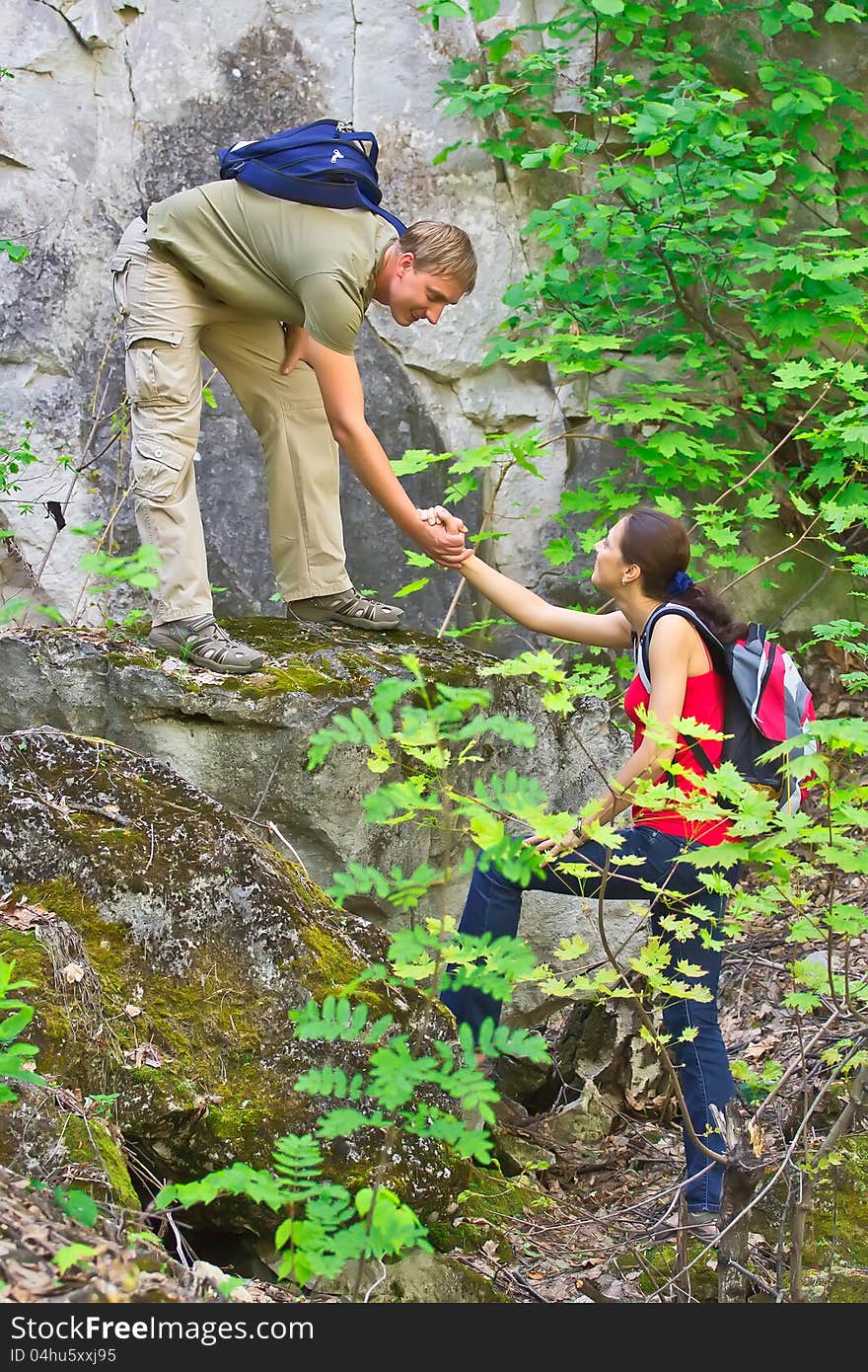 The young men helps the girl back to сскале. The young men helps the girl back to сскале