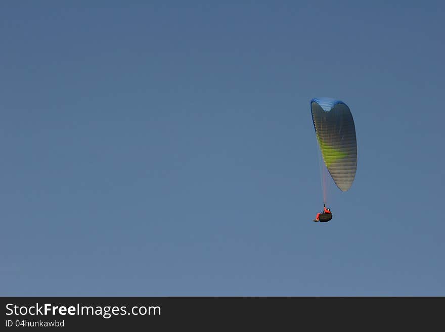 A paraglider on a blue sky at a seaside