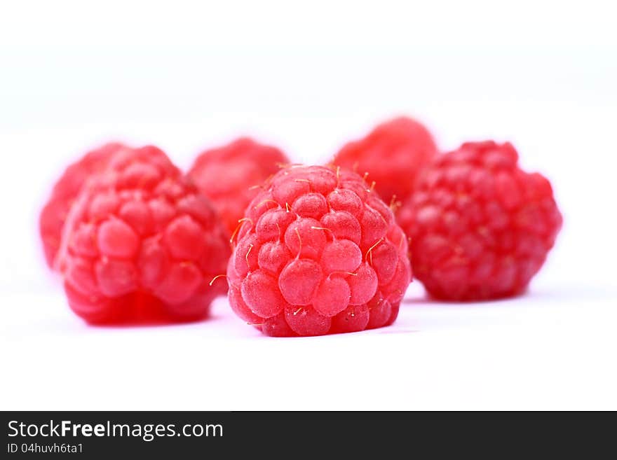 Ripe raspberries on white , macro