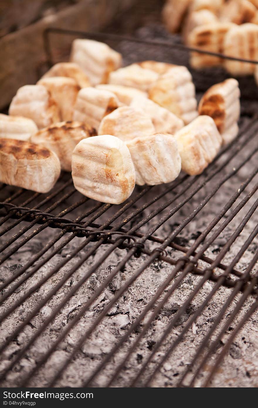 Traditional African 'roosterkoek' baking on metal grid over hot coals. Traditional African 'roosterkoek' baking on metal grid over hot coals