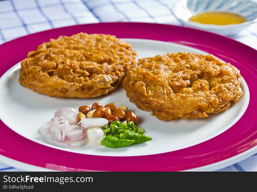 Thai style minced pork omelet in pancake shape, served with sliced shallot, peanut, chilli and fish sauce