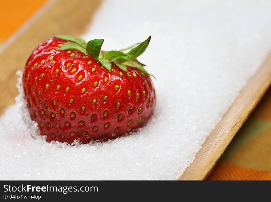 A strawberry is lying in sugar