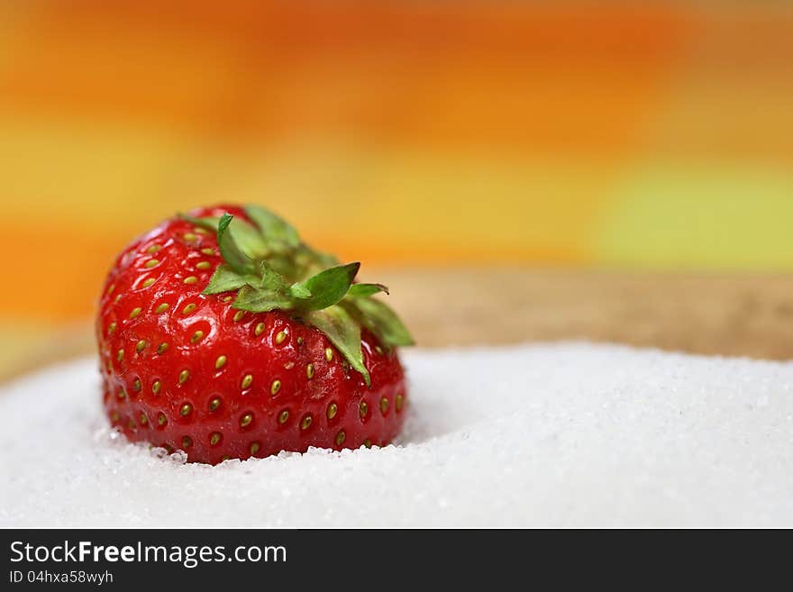 A strawberry is lying in sugar