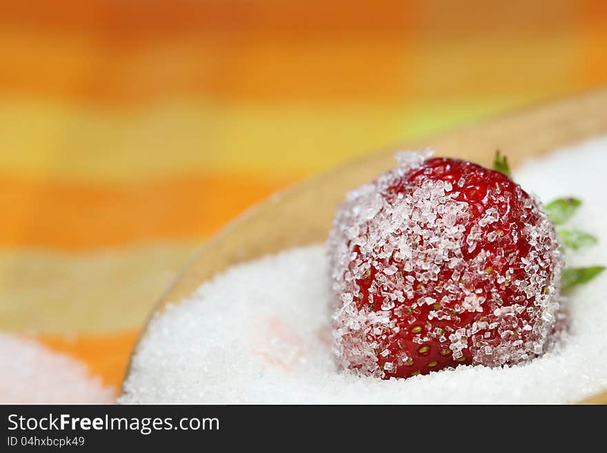 A strawberry is lying in sugar