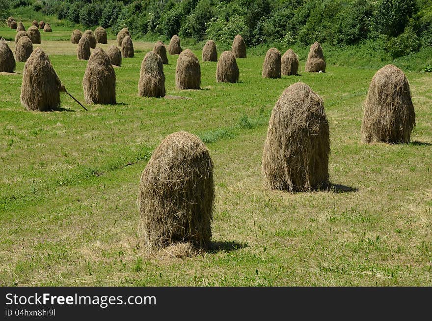 Haycock on green hill and forest rural agriculture. Haycock on green hill and forest rural agriculture