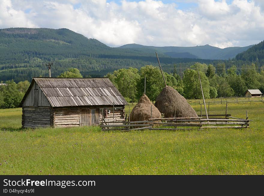 Haycock and old house in generic transylvania village. Haycock and old house in generic transylvania village