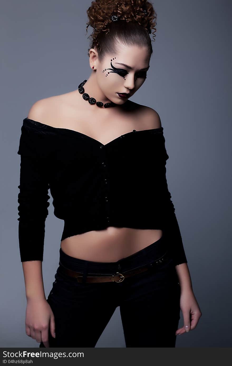 Young slim lady in black with creative makeup posing. Young slim lady in black with creative makeup posing