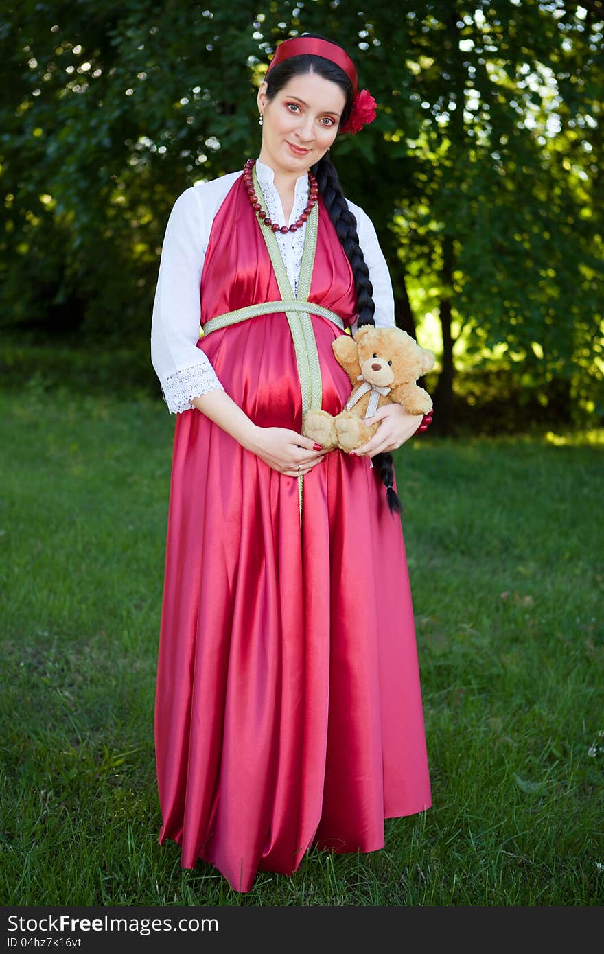 A young pregnant girl in a red dress